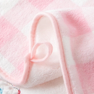 Close-up of pink checkered coral fleece towel detailing soft texture and hanging loop