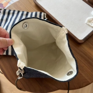 Internal view of minimalist denim crossbody bag with canvas lining and magnetic closure