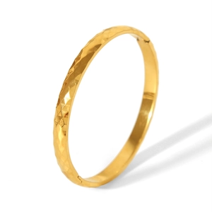 Detail of 18k gold plated stainless steel bangle with elegant diamond lattice texture