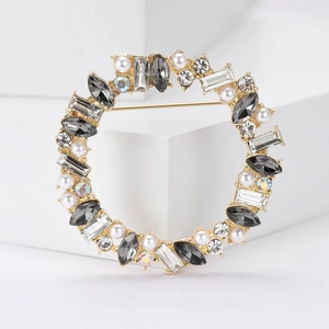Elegant gold wreath brooch featuring grey marquise rhinestones and white pearls on white base