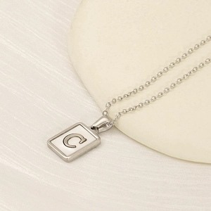 Minimalist stainless steel necklace featuring a square white shell pendant with letter C