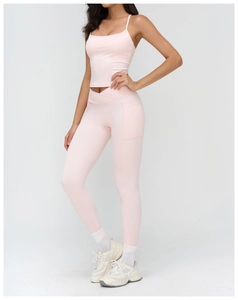 Pink yoga set detail featuring high-waisted leggings with hidden side pockets and thin straps
