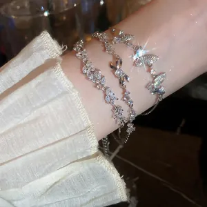 Three-piece set of silver zircon flower and butterfly bracelets on female wrist