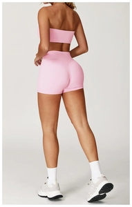 Rear view of pink high-waist yoga shorts and matching sports top showing body contour