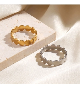 Detail of gold and silver beaded stackable rings on stone and satin background