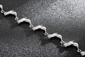 Détail macro de maillons en forme de talons hauts sur un bracelet en acier titane poli