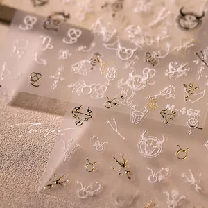 Makroaufnahme von Stier-Sternbild-Nagelstickern mit metallisch goldenen Prägelinien