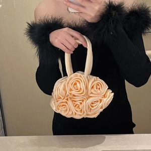 Mirror selfie showing the champagne satin rose handbag carried by a model