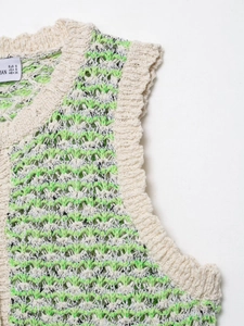 Detailed close-up of textured knit top in cream and lime green with EUR S size label