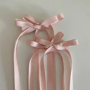 Vue détaillée des nœuds en satin rose avec de longs rubans élégants et texture lisse