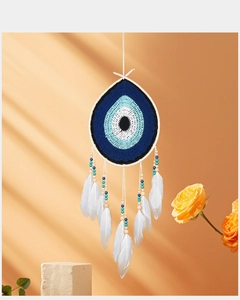 Macro detail of Bohemian evil eye dream catcher with white feathers and blue beads