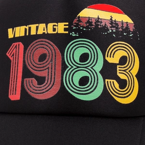 Close-up of vintage 1983 colorful print on black mesh trucker hat showing high detail