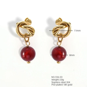 Detailed view of 18K gold plated bow earrings with red beads and dimension specs
