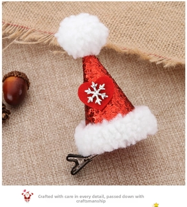 Detail showing a sequined Christmas hat hair clip with a plush pom-pom and snowflake decor