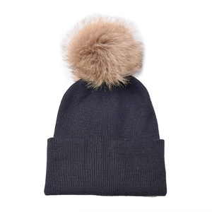 Close-up of the thick ribbed knit texture and large fluffy faux fur pompom in dark black