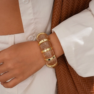 Detail of chunky amber acrylic resin bracelet with gold glitter and metal ring links