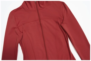Détail d'une veste de yoga rouge foncé avec col montant et coutures ergonomiques