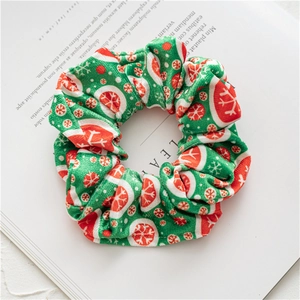 Detail of Christmas scrunchie with snowflake prints on soft green velvet fabric
