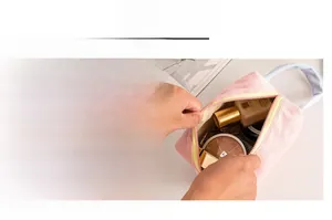 Dettaglio della borsa cosmetica in velluto a coste rosa con cerniera gialla e interno