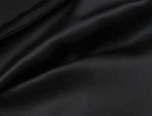 Detail shot of black satin fabric showing smooth texture and luxurious silk-like sheen
