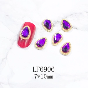 Detalle de gema violeta para uñas LF6906 con borde dorado en fondo mármol