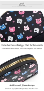 Detail view of the black leather wallet featuring cartoon bear prints and gold metal zipper
