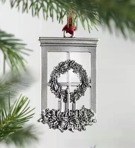 Detail of vintage silver metal Christmas pendant with wreath and candles on pine tree