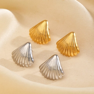 Shell shaped stud earrings in gold and silver finish on silk fabric for a beach holiday look