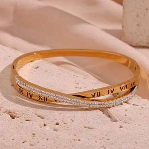 Macro shot of 18K gold plated cross bangle with micro-pave crystals and Roman numerals