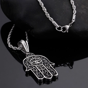Detail of silver Hamsa hand pendant with evil eye on a textured twist chain