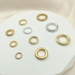 Assortimento di anelli di connessione fai-da-te in oro e argento su piedistallo bianco