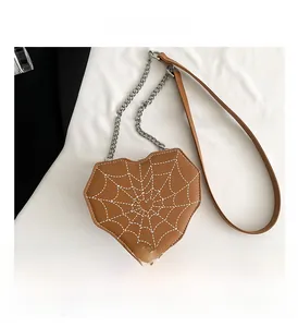 Detalle de bolso bandolera marrón con forma de corazón y costuras de telaraña blanca