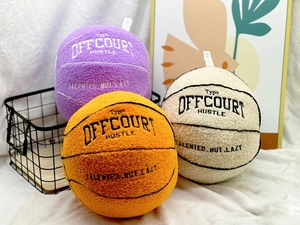 Detailed plush basketball pillows with embroidered Typo Off Court Hustle text
