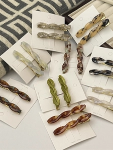 Macro shot of assorted tortoiseshell and acetate twist hair clips on card packaging