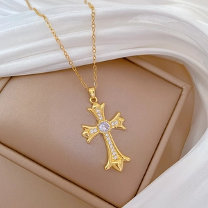 Detailed macro view of an ornate gold cross pendant with shimmering cubic zirconia inlay