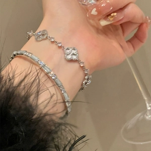 Elegant silver shell flower bracelet and sparkling zircon bangle layered on a wrist