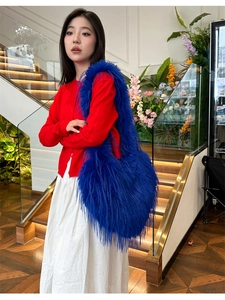 Blue faux fur shoulder bag with long plush texture shown on model in detail view