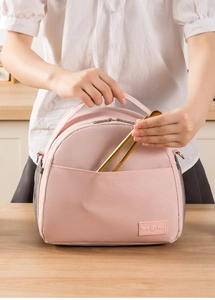 Pink insulated lunch bag with side mesh pocket and Tasty Food label shown in a kitchen