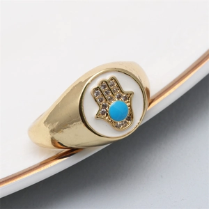 Detailed view of gold Hamsa ring with blue evil eye bead and pavé zircon stones