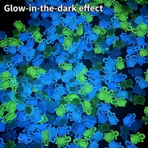Glow-in-the-dark miniature resin turtles in neon green and blue colors on dark background