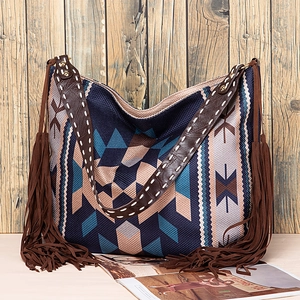 Detail of woven bohemian tote bag featuring long brown tassels and ethnic patterns