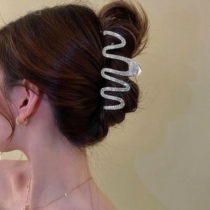 Detail of a large S-shaped wave hair claw clip with silver rhinestones for elegant updos