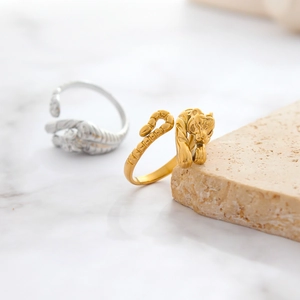 Tiger head gold and silver stainless steel couple rings on a stone display