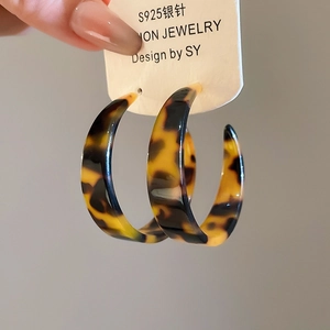 Gros plan de boucles d'oreilles créoles C en écaille de tortue avec tiges en argent S925