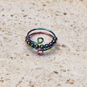 Detailed top view of rainbow titanium steel fidget ring with rotatable beads on stone