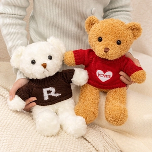Ours en peluche en pulls tricotés avec motifs de cœur sur une couverture texturée