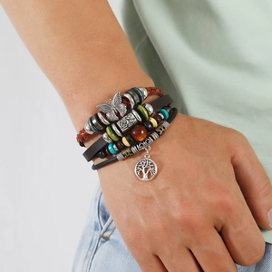Mehrlagiges Lederarmband mit Schmetterling und Lebensbaum-Anhänger am Handgelenk