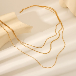 Detailed close-up of triple-layered 18K gold plated stainless steel necklace on white background