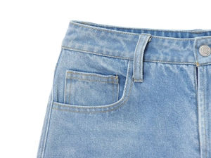 Détail de la taille du jean bleu clair avec bouton en métal et coutures de poche