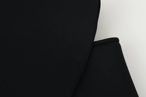 Close-up of high-quality black fabric texture and fine stitching on the slim blazer sleeve